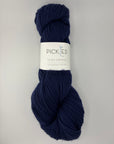 Navy blue skein of yarn with a label on a light gray background
