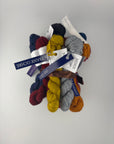 Collection of colorful Malabrigo Ultimate Sock yarn mini skeins with labels on a white background