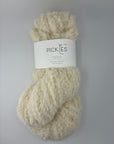 one skein of cream-colored boucle yarn with a label on a light gray background