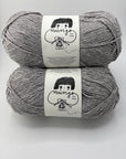 Two skeins of gray yarn with labels on a white background