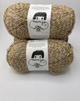 Two skeins of tan, yellow and gray marled yarn with labels on a white background