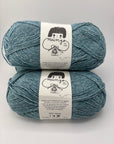 Two skeins of blue yarn with labels on a light gray background