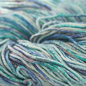 A close-up image of a multicolored worsted weight yarn skein with vibrant splashes of blue, teal, white, and green.