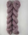 Two skeins of purple yarn on a white background