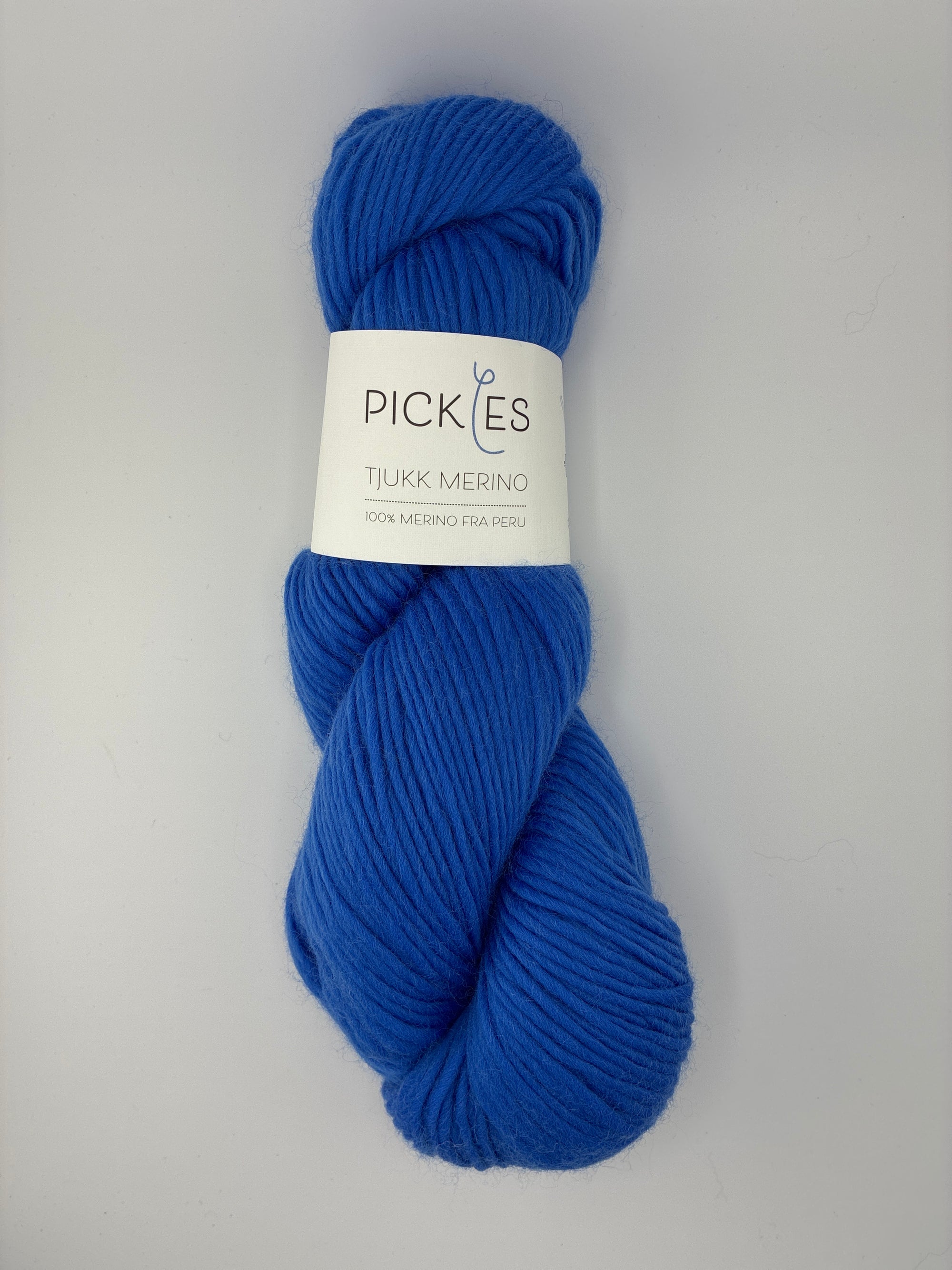 Blue skein of yarn with a Pickles label on a gray background