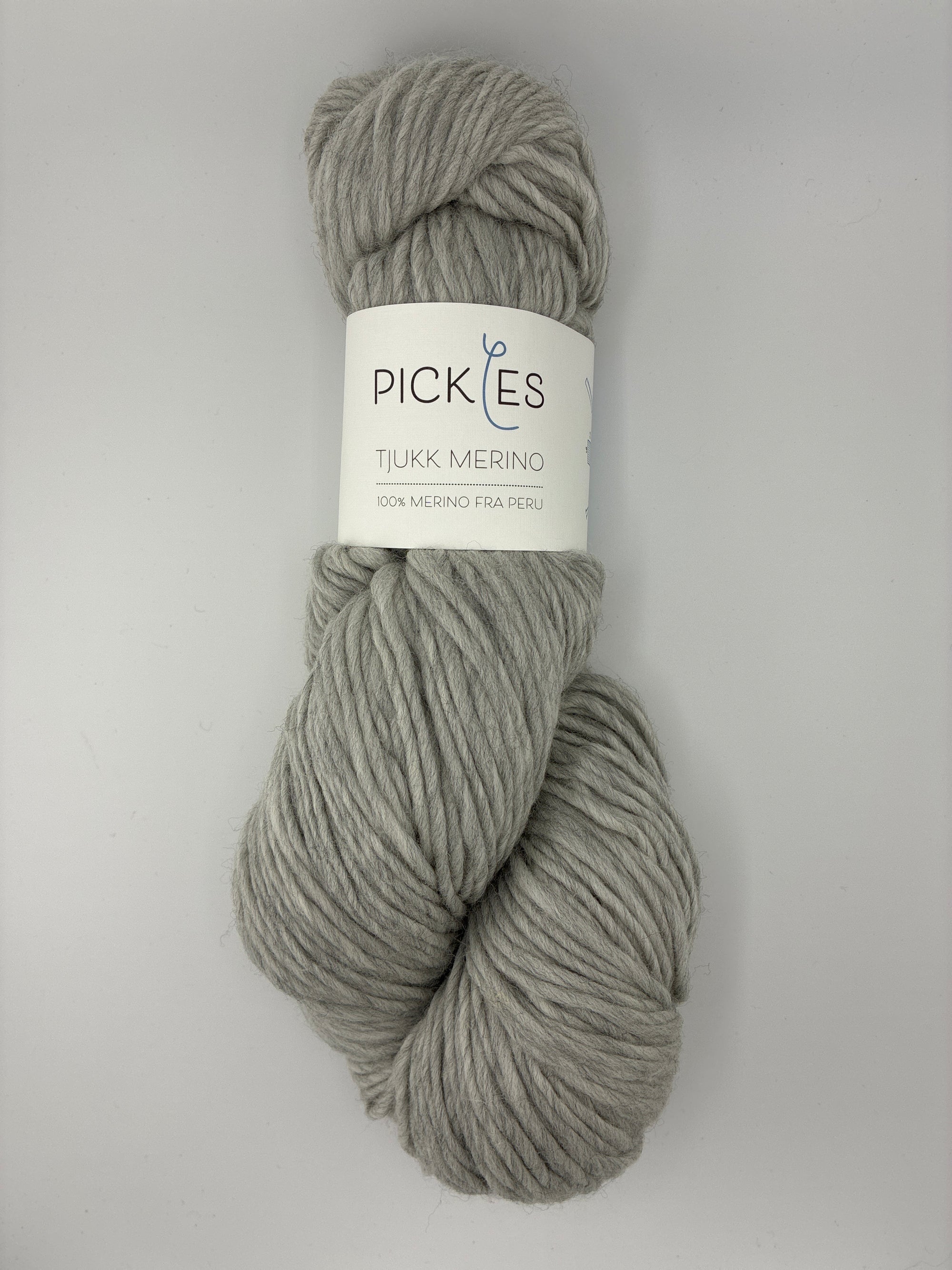 Gray skein of yarn with a label on a light gray background