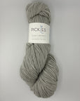 Gray skein of yarn with a label on a light gray background