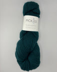 Dark Green skein of yarn with a label on a light gray background