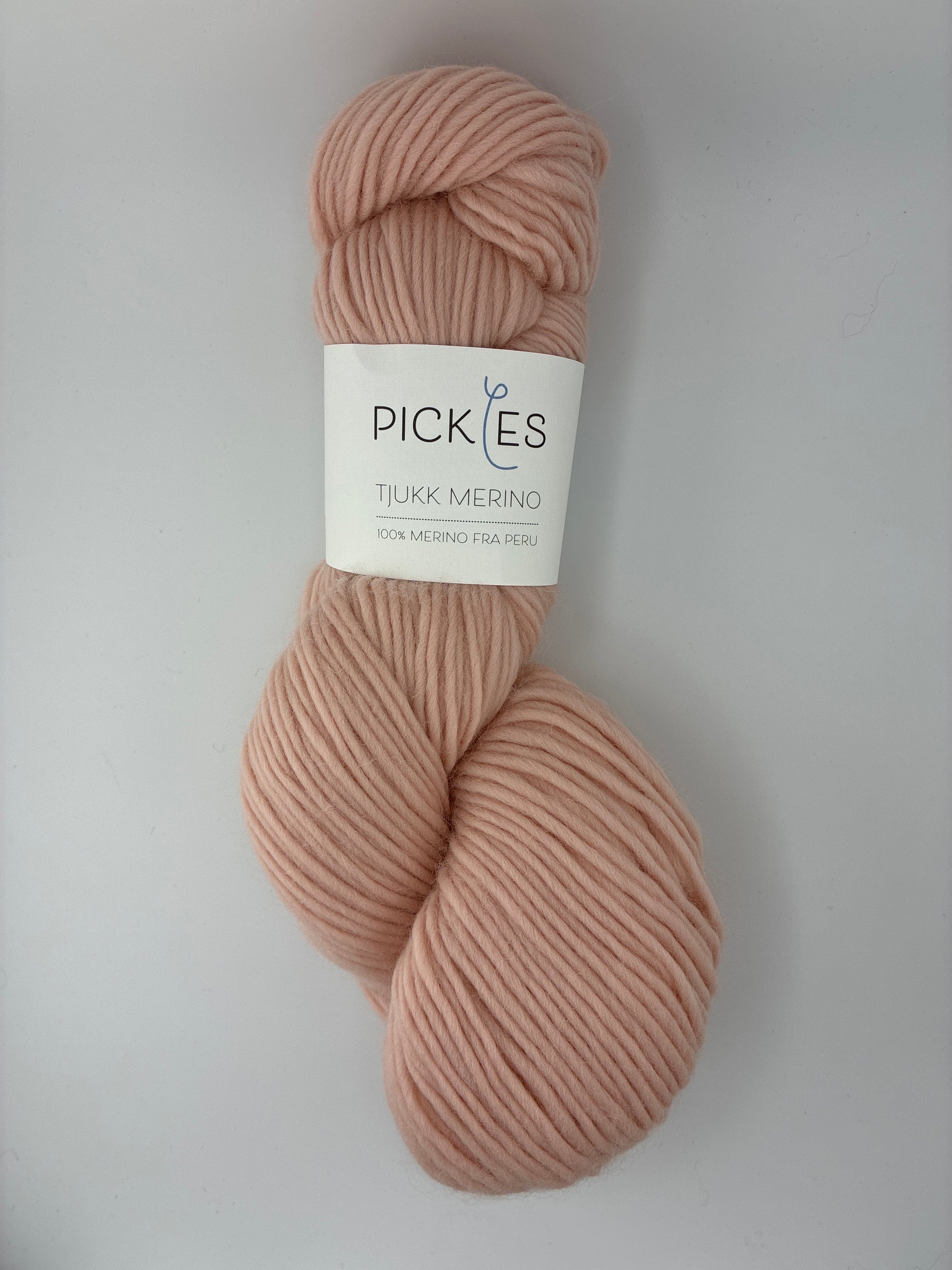 Single skein of pink yarn with a Pickles label on a light gray background