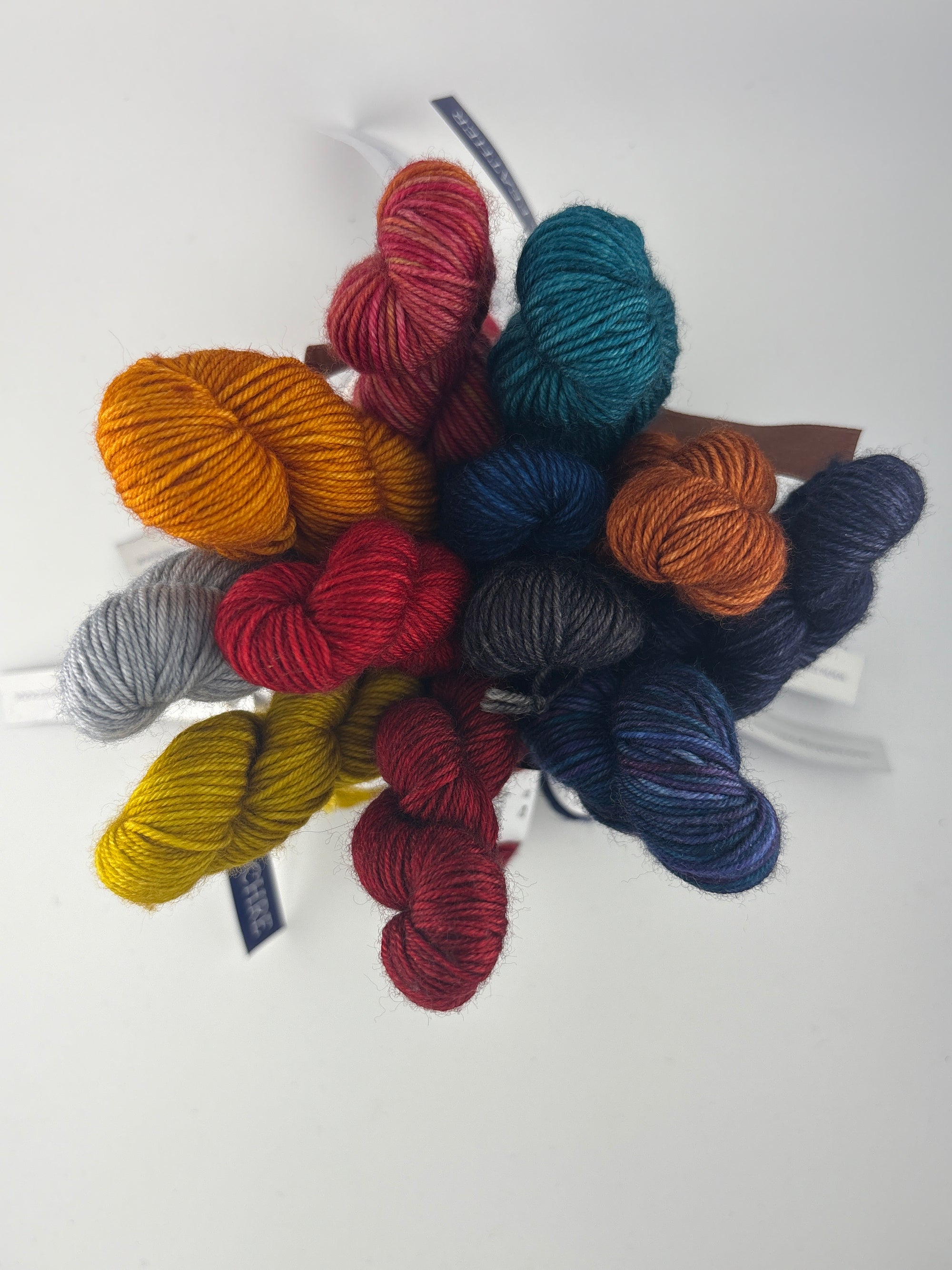 Collection of colorful Malabrigo mini skeins on a white background