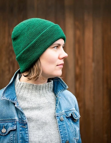 Ysolda wearing a green Musselburgh hat and denim jacket over a gray sweater.