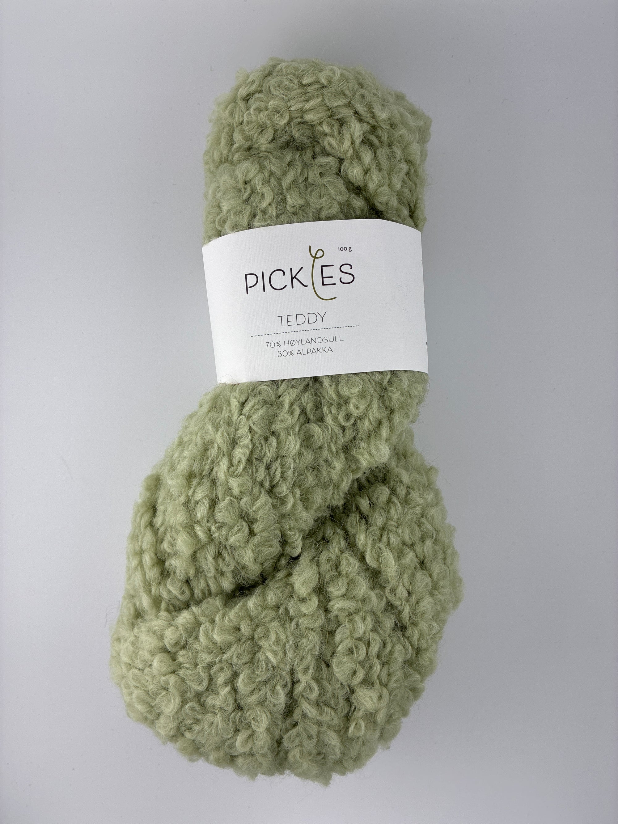 Green boucle yarn with a label on a gray background