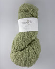 Green boucle yarn with a label on a gray background