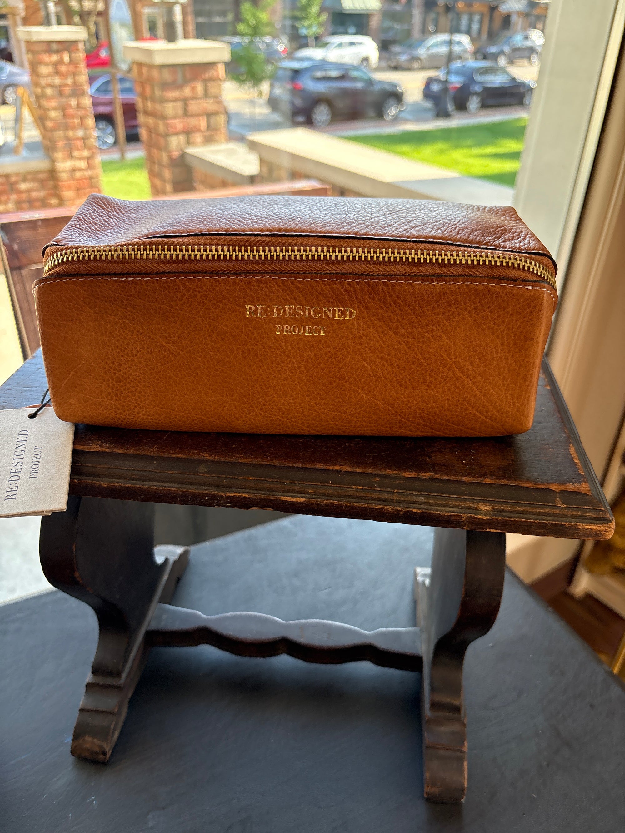 Brown leather Re:Designed project 41 bag on a wooden stand.