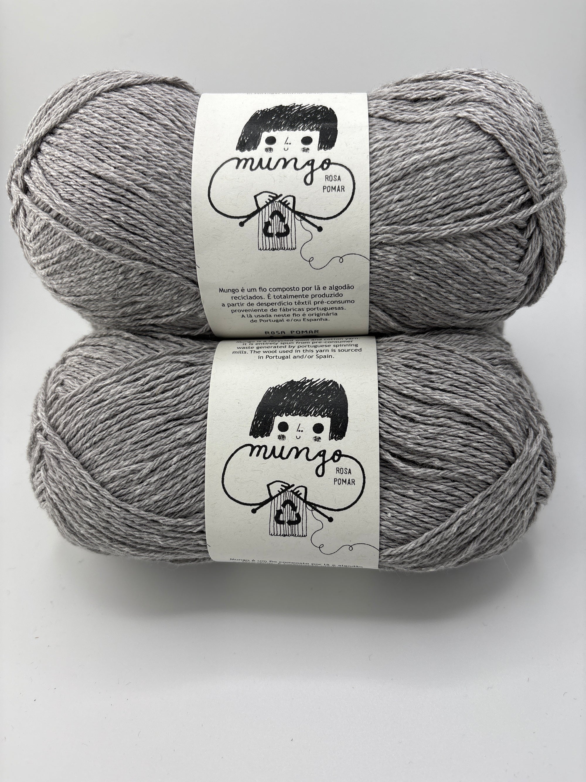 Two skeins of gray yarn with labels on a white background