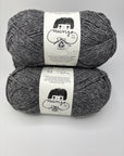 Two skeins of charcoal gray yarn with labels on a white background