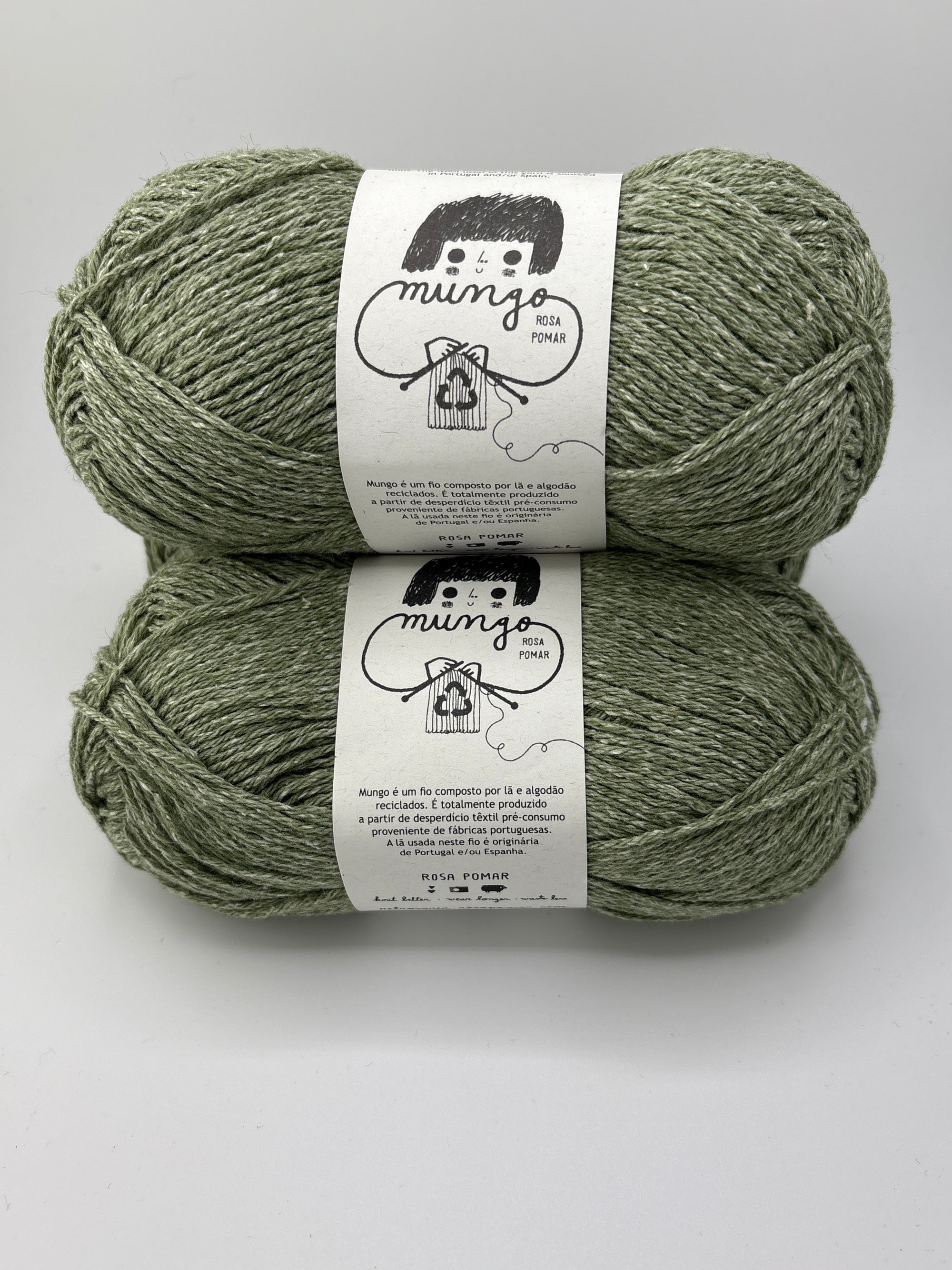 Two skeins of green yarn with labels on a white background
