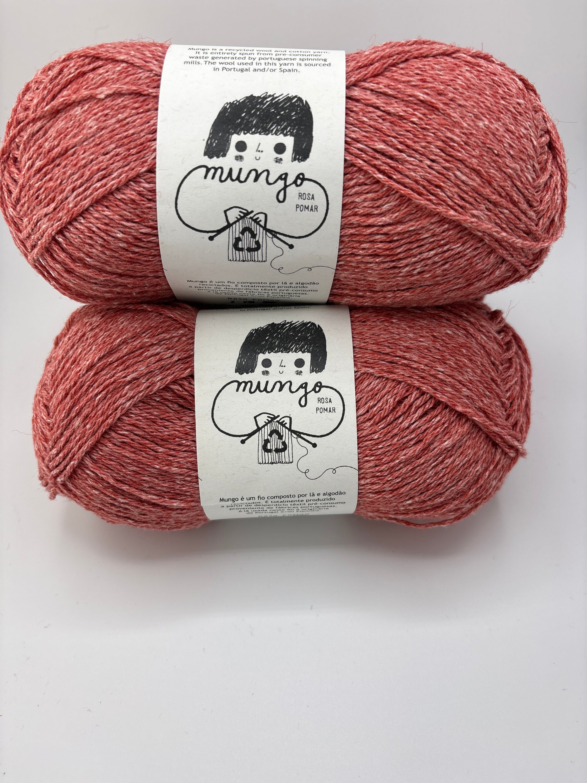 Two skeins of pink yarn with labels on a white background