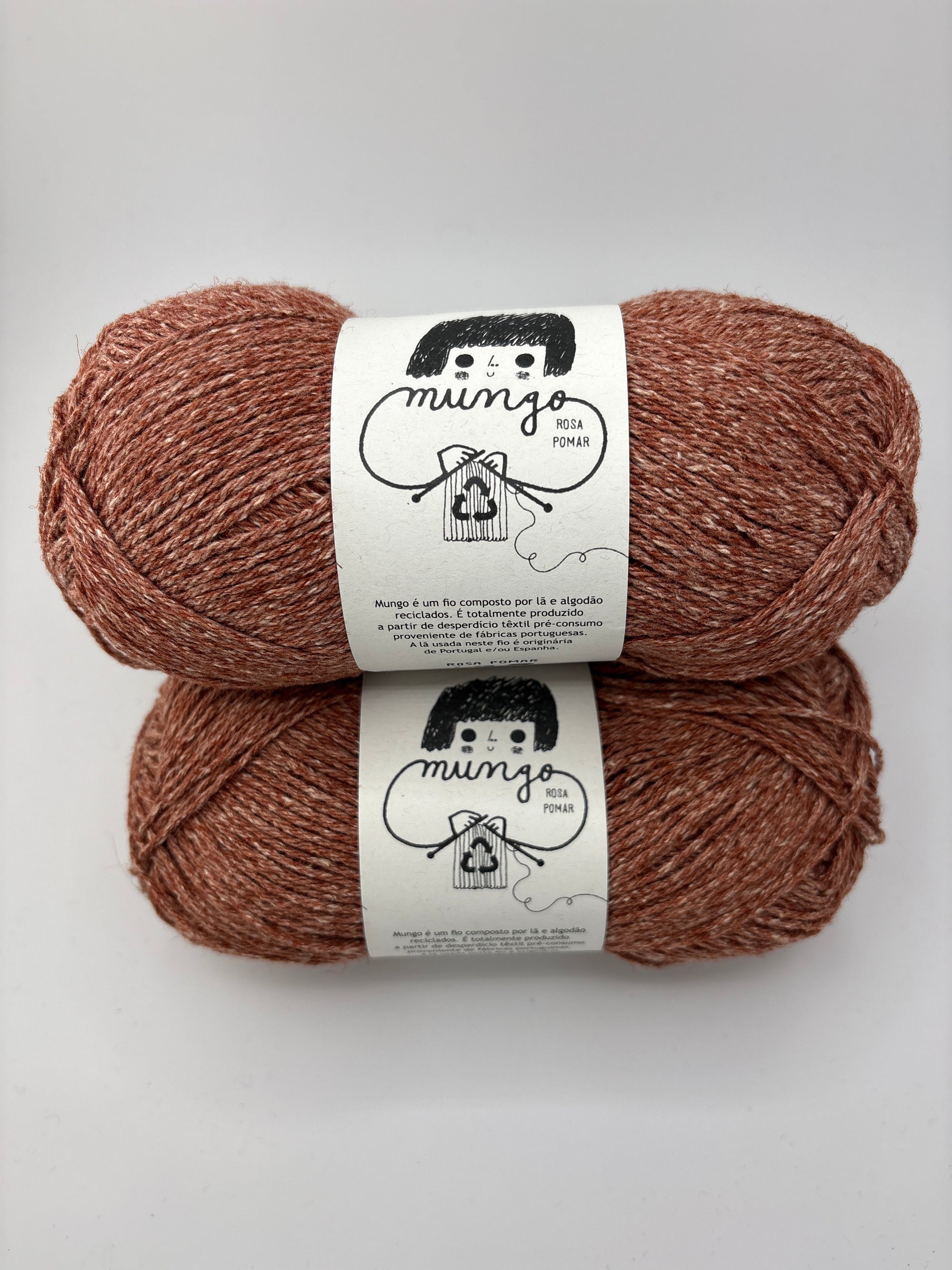 Two skeins of brown yarn with labels on a white background