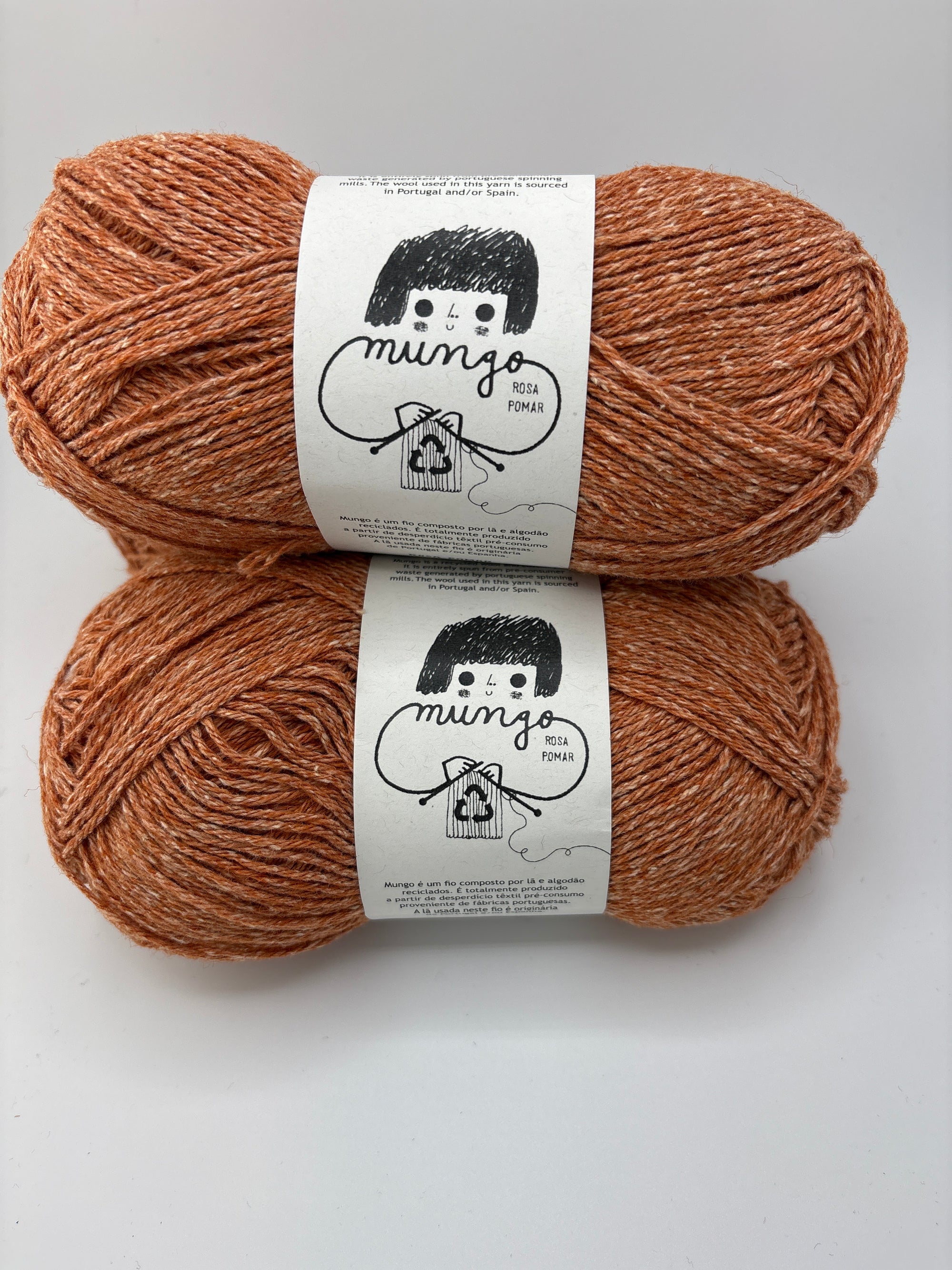 Two skeins of brown yarn with labels on a white background