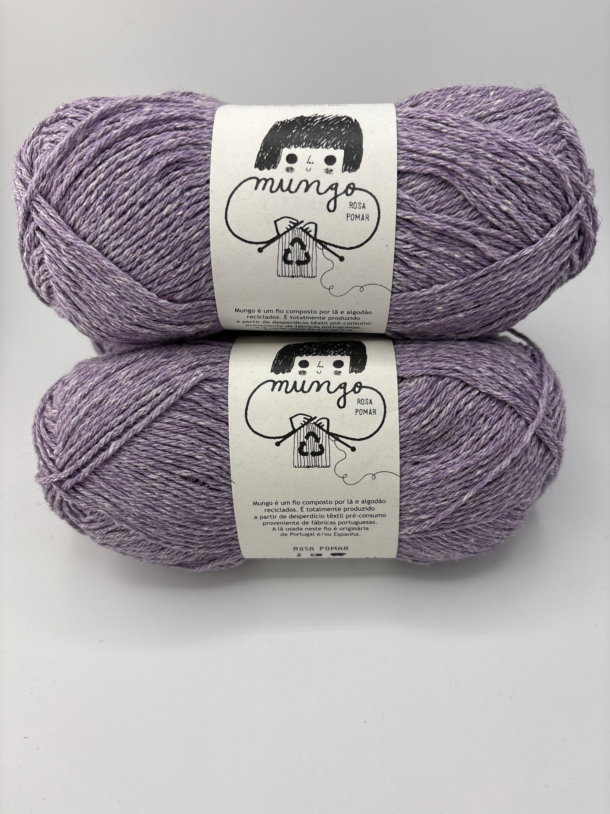 Two skeins of purple yarn with labels on a white background
